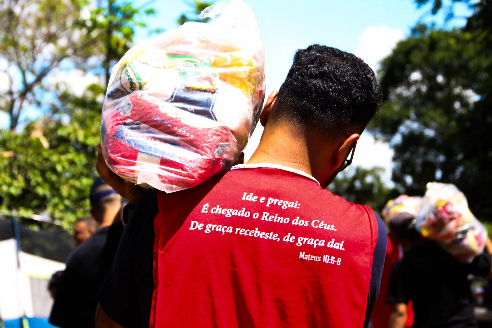 Voluntário levando cesta básica